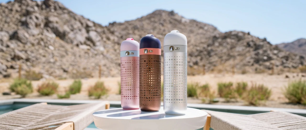 Three OKAPA luxury water bottles in a desert landscape — from the Fast Company feature